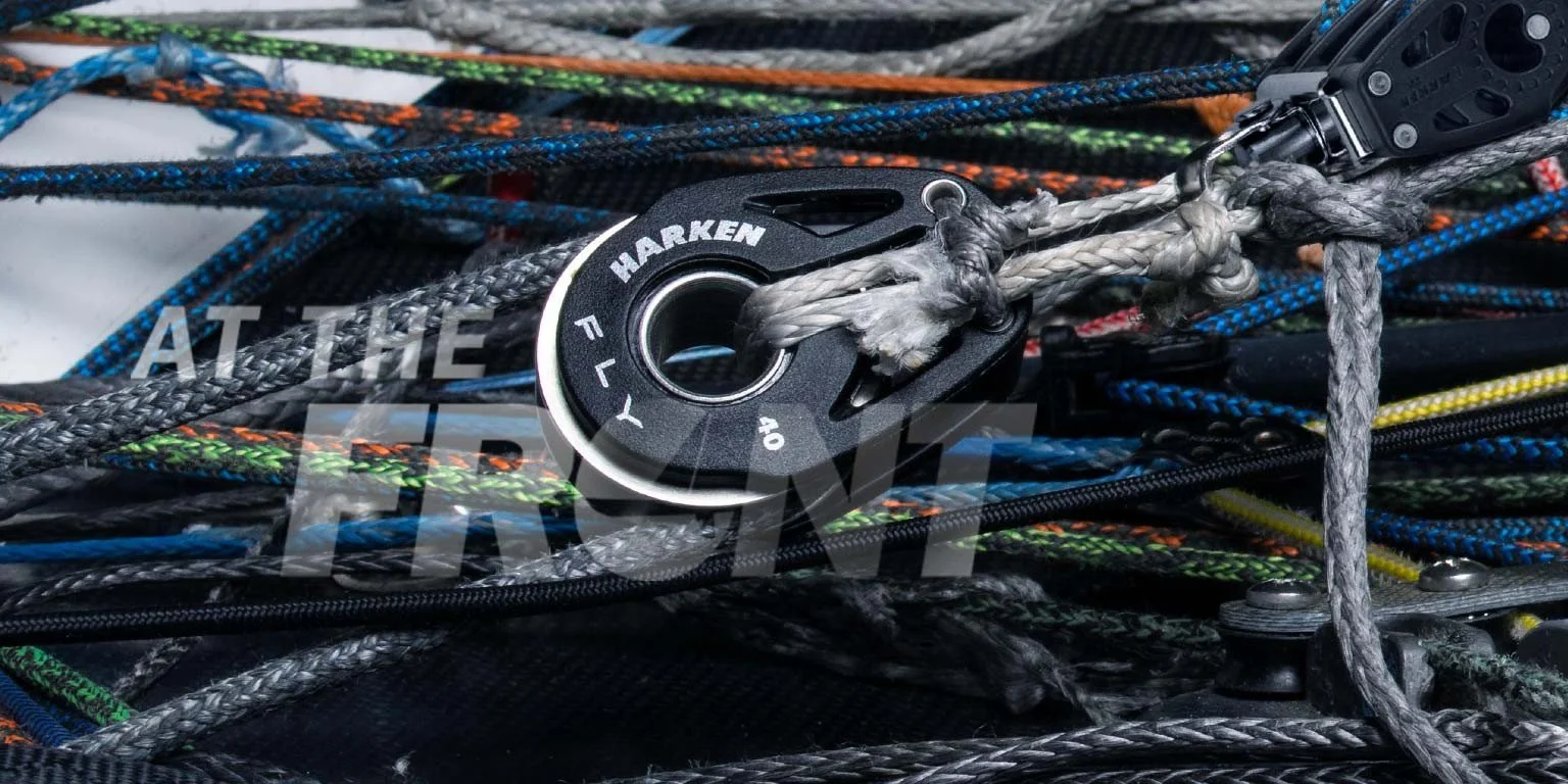 Close-up of a black Harken pulley block labeled 'Fly 40' with colorful sailing ropes.